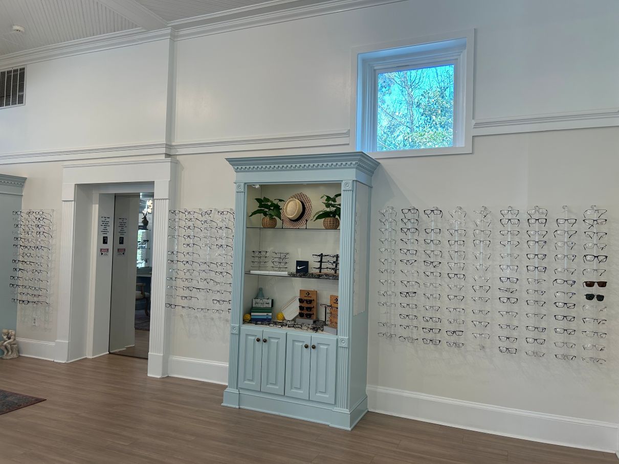 White gallery room with built-in wall displays and a light blue cabinet beneath a small window near Fayetteville, NC.