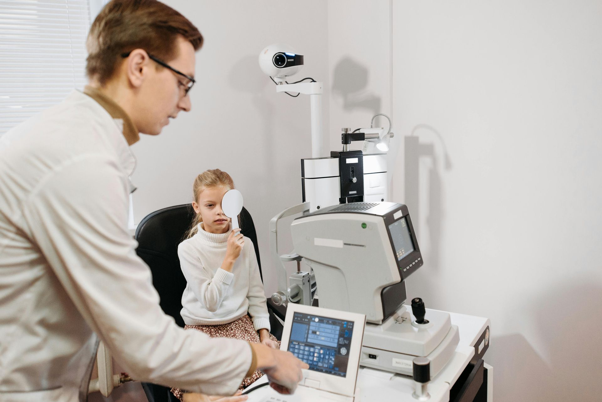 Doctor examining child with medical equipment in a clinic room near Fayetteville, NC.