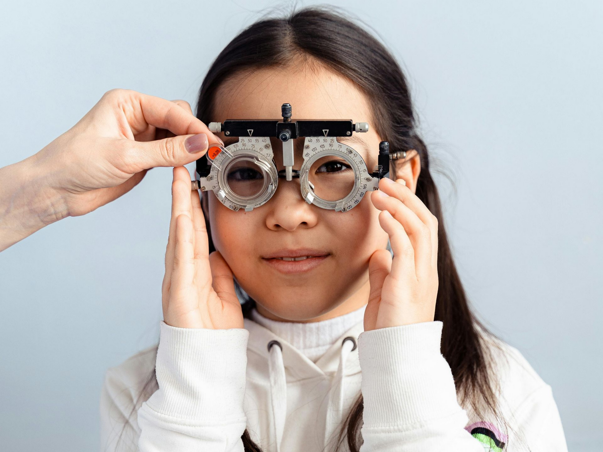 Person holding a trial frame eyeglasses fitting tool in a bright setting near Fayetteville, NC.