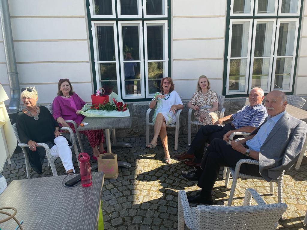 A group of people are sitting around a table on a patio.