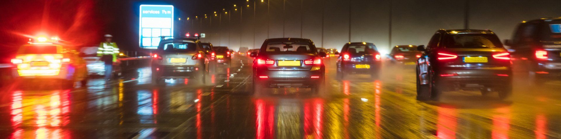 A blurry picture of a busy highway at night in the rain.