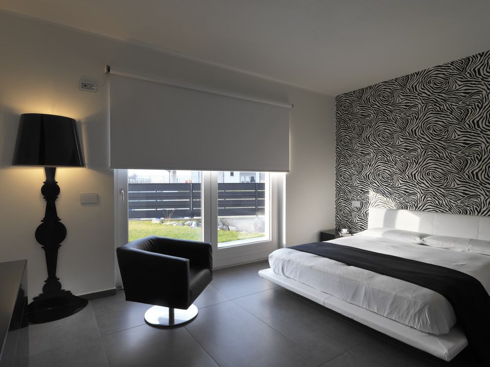 A Bedroom with a Bed a Chair and a Lamp — Hunter Valley Tile Mart in Rutherford, NSW