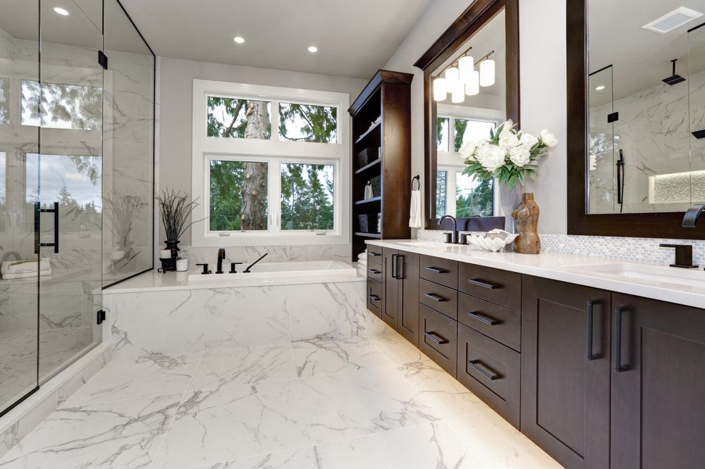 A Bathroom with a Bathtub, Sinks, Mirrors and Marble Floors — Hunter Valley Tile Mart in Thornton, NSW
