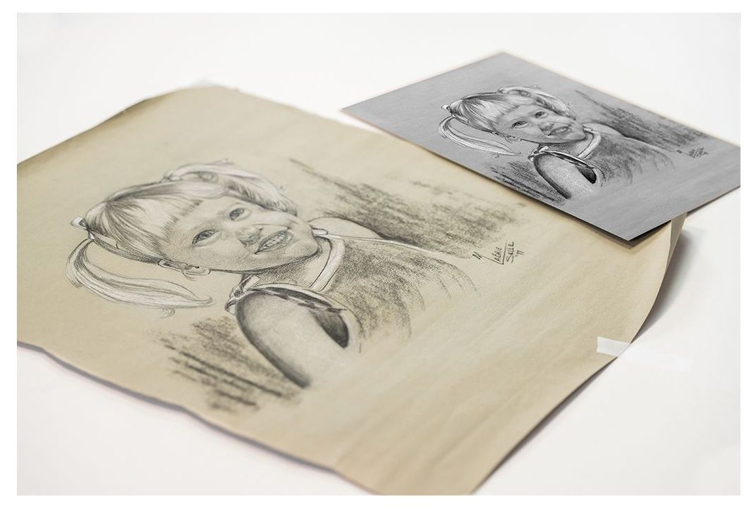 Two sketch portraits on cream and gray paper, with a folded corner on the top sheet