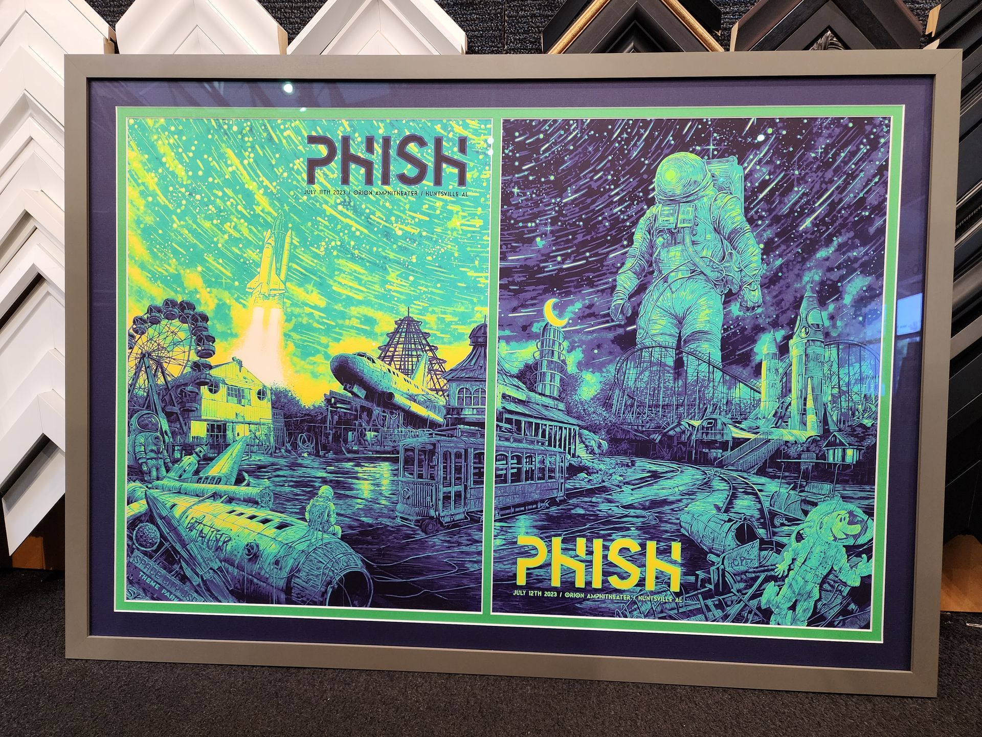 Framed neon green and purple PHISH poster with two concert scenes side by side.