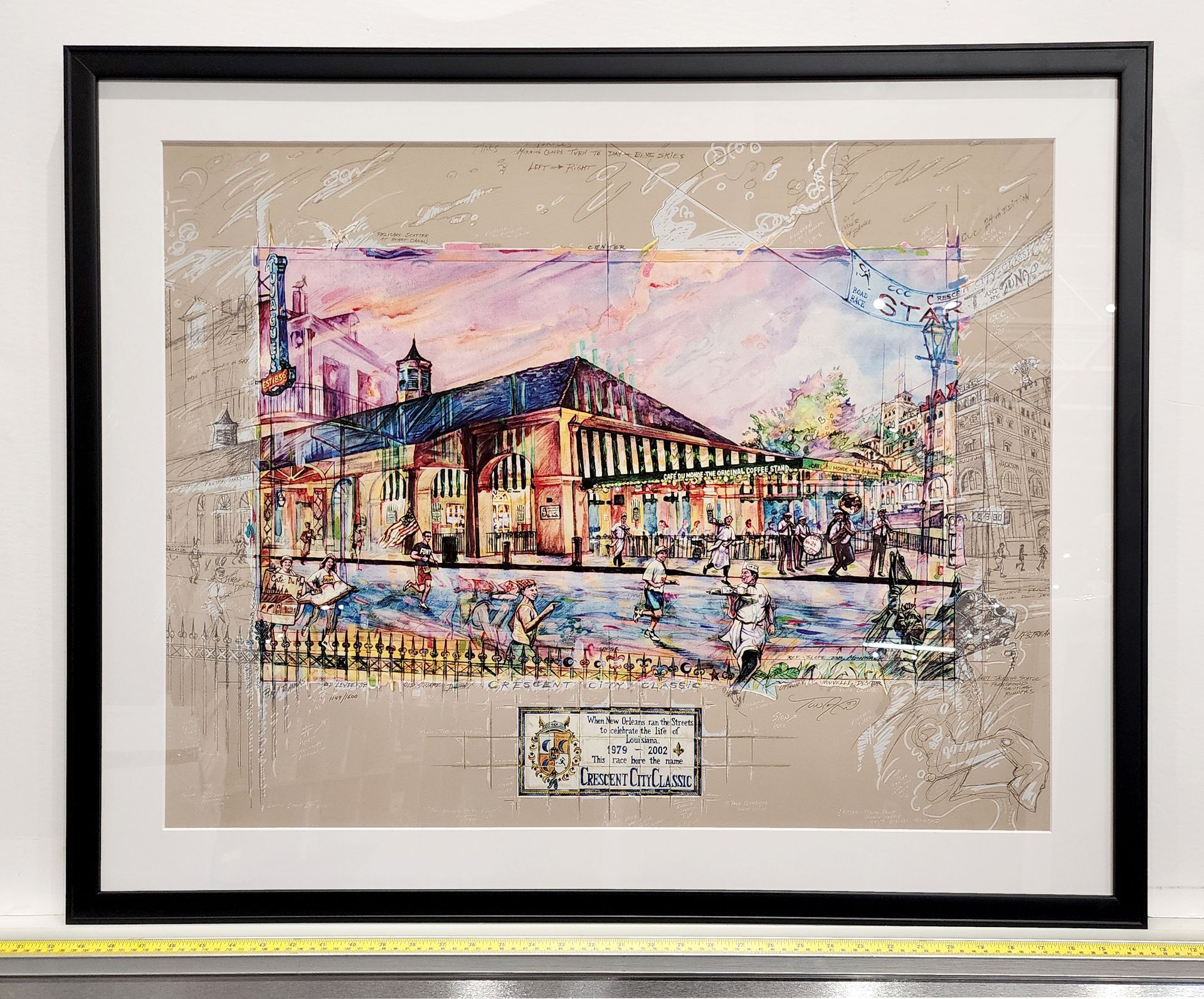 Framed colorful painting of a city building and street scene with reflections and pastel sky
