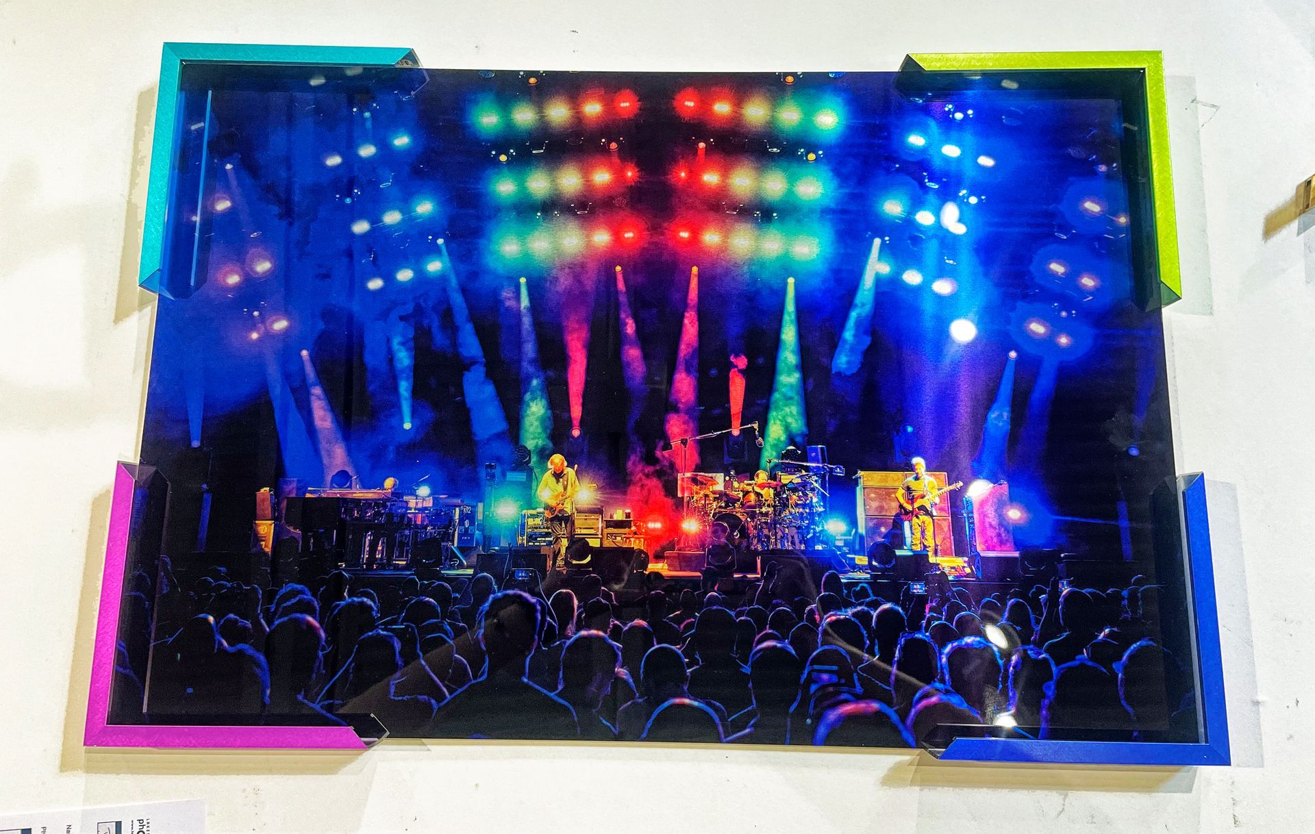 Colorful concert stage with bright blue, red, and green lights over a cheering crowd