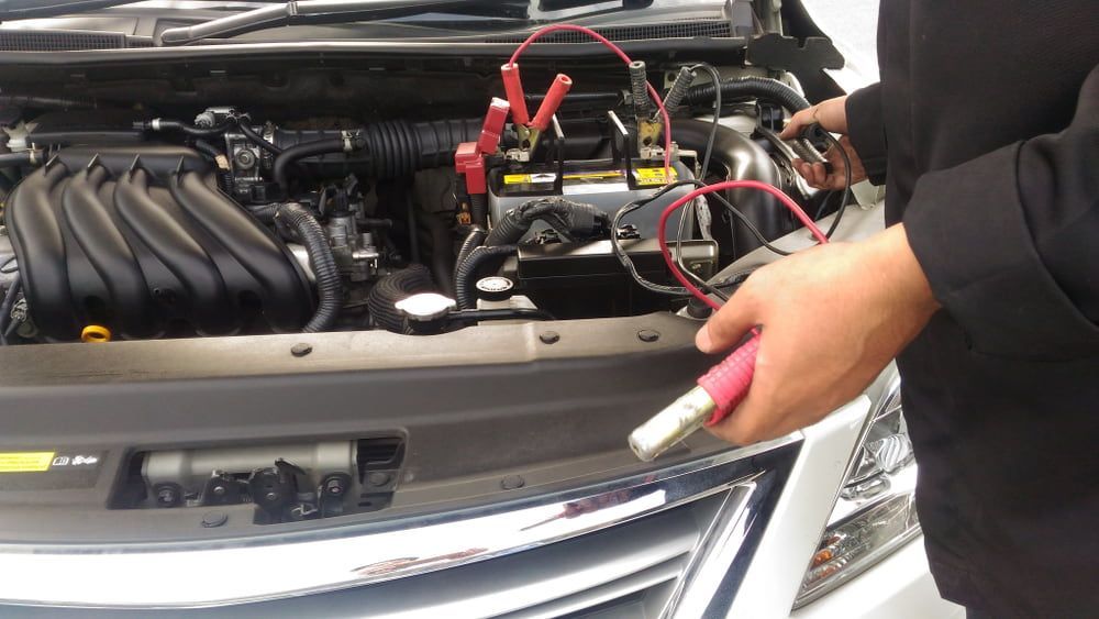 A Person is Charging a Car Battery With a Charger — Jim Wall Automotive in Moss Vale, NSW