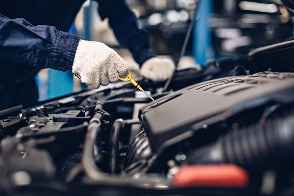 A Person is Checking the Oil Level in a Car Engine — Jim Wall Automotive in Bowral, NSW