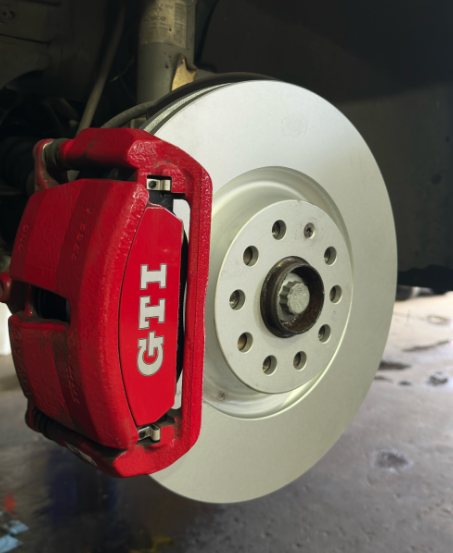 A Red GTI Brake Caliper on a White Wheel — Jim Wall Automotive in Moss Vale, NSW