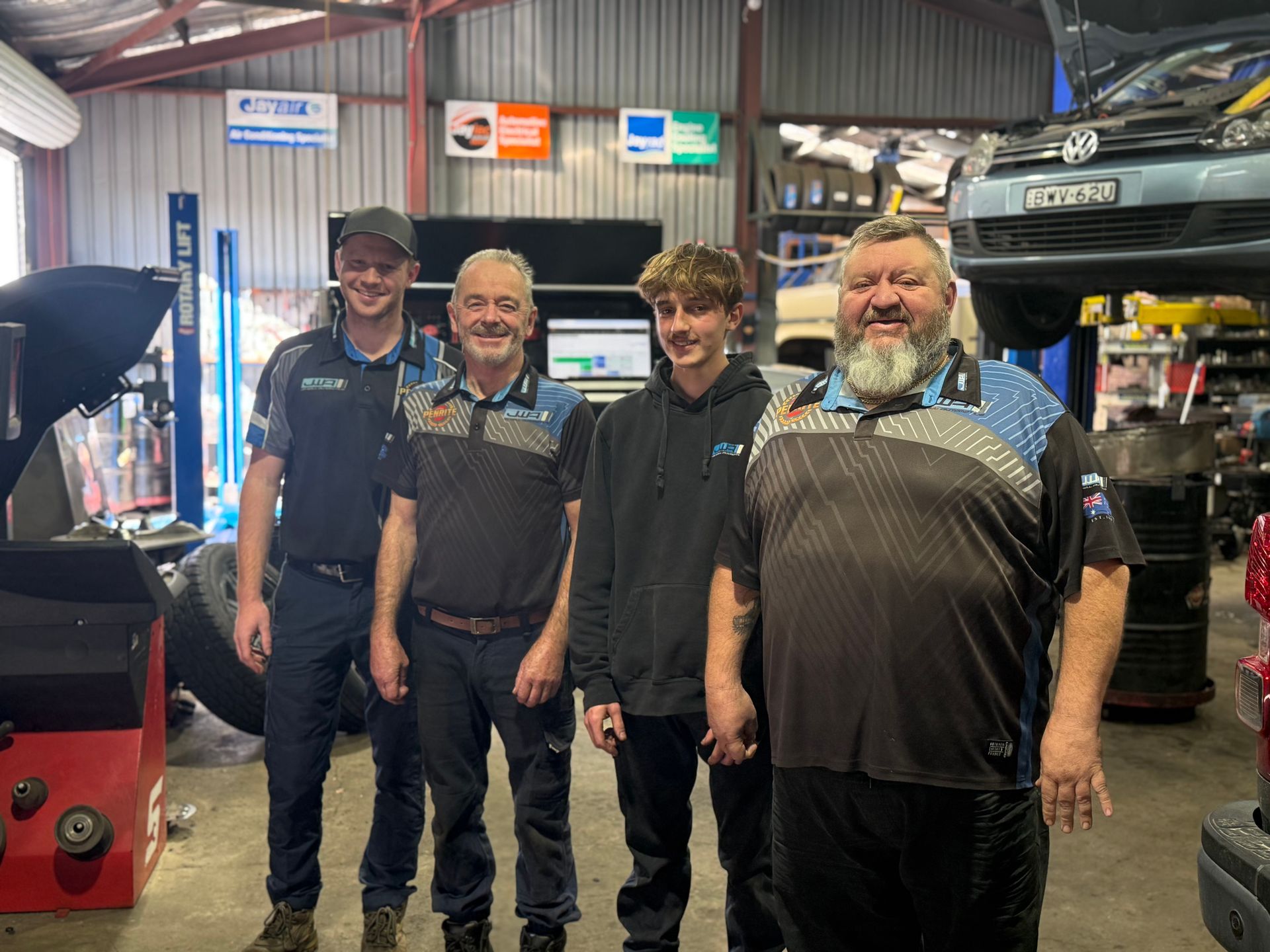 A mechanic team are standing posing for a photo — Jim Wall Automotive in Mittagong, NSW