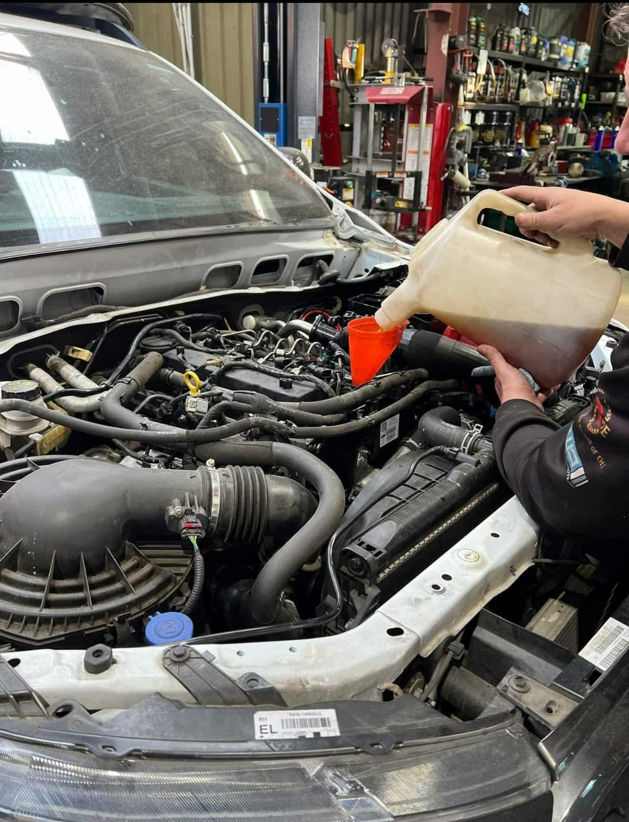 A car engine with oil being poured in — Jim Wall Automotive in Mittagong, NSW