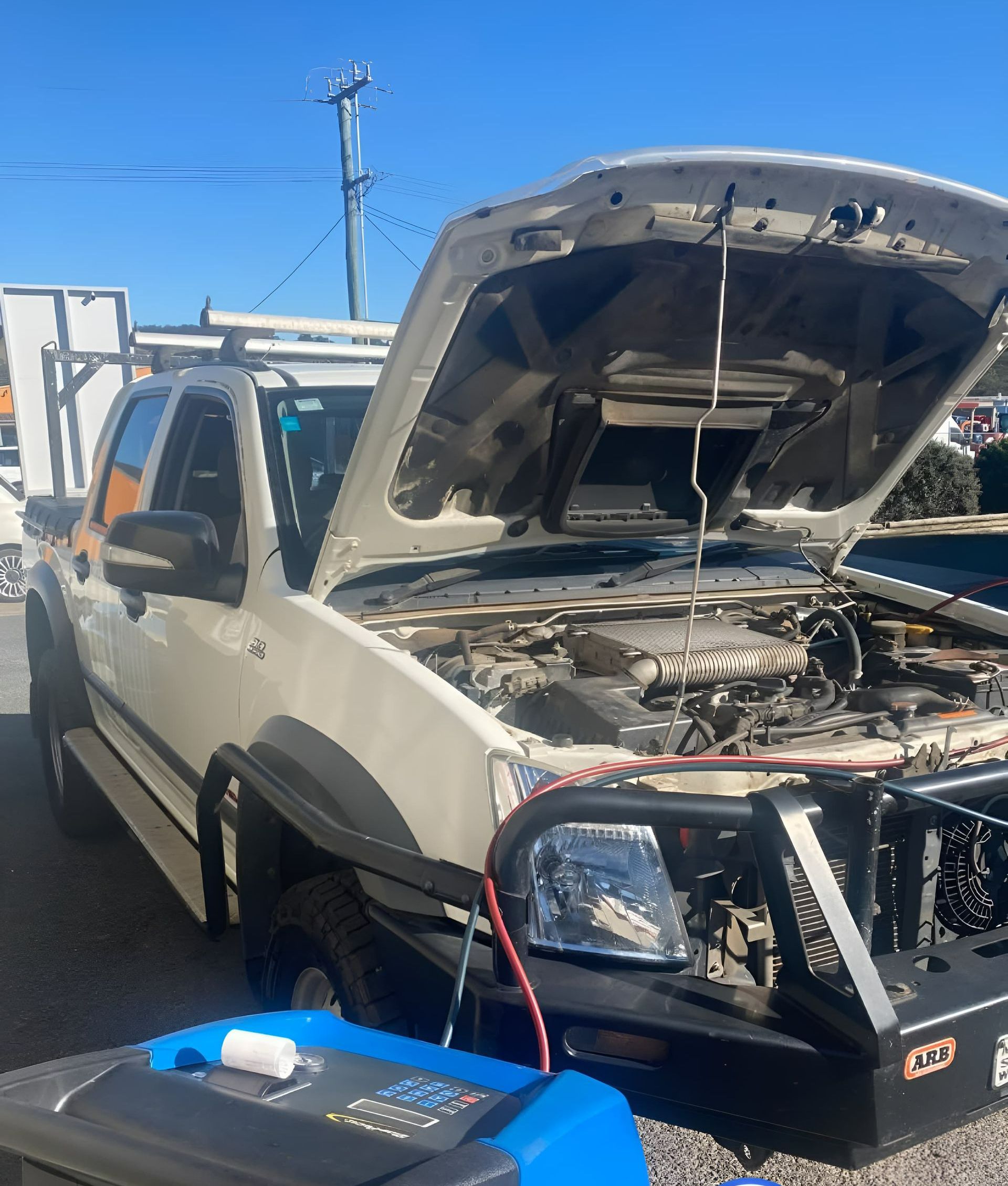 A White Truck With the Hood Up is Parked Next to a Generator — Jim Wall Automotive in Moss Vale, NSW