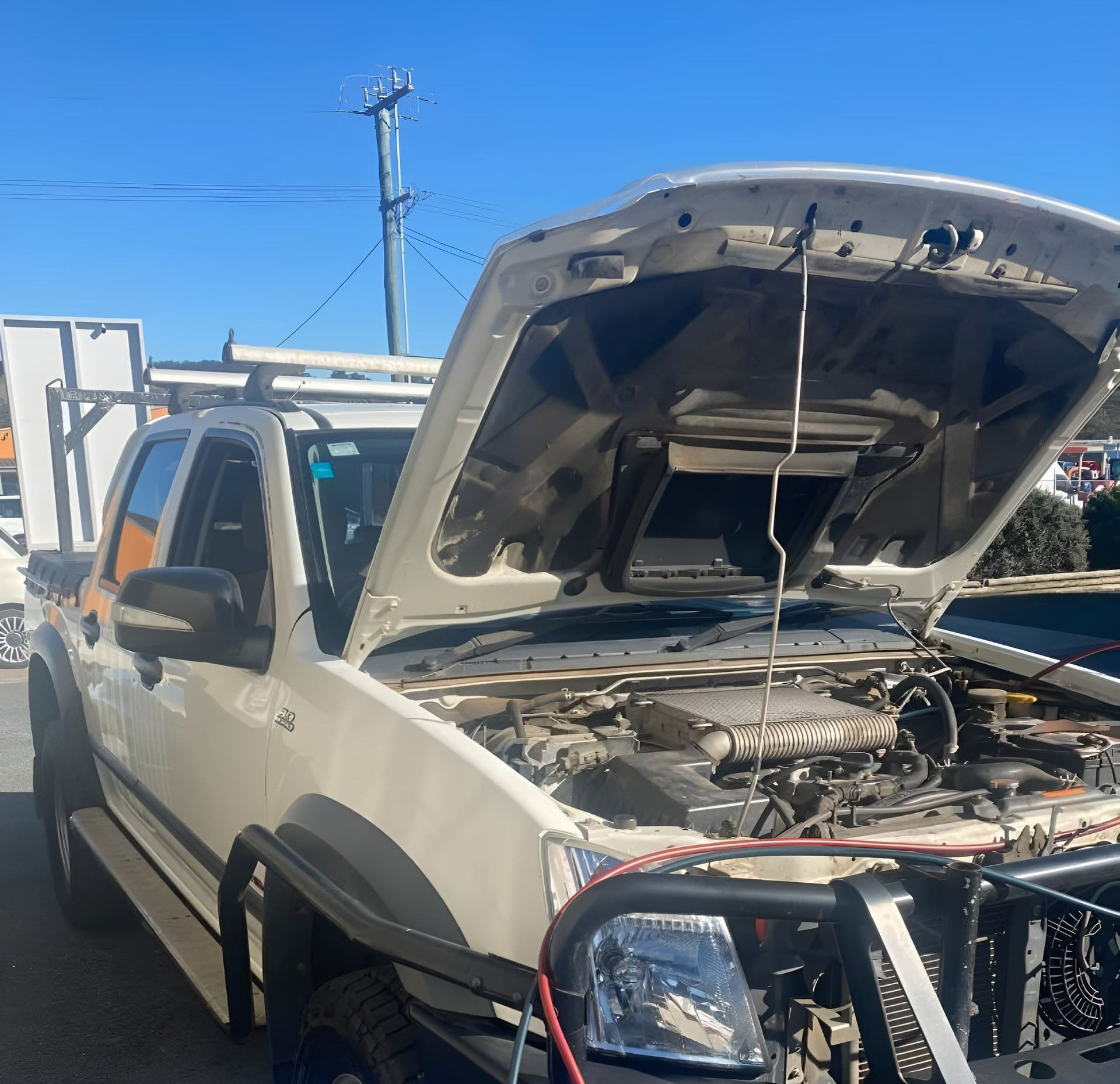 A white ute hood is open — Jim Wall Automotive in Bowral, NSW