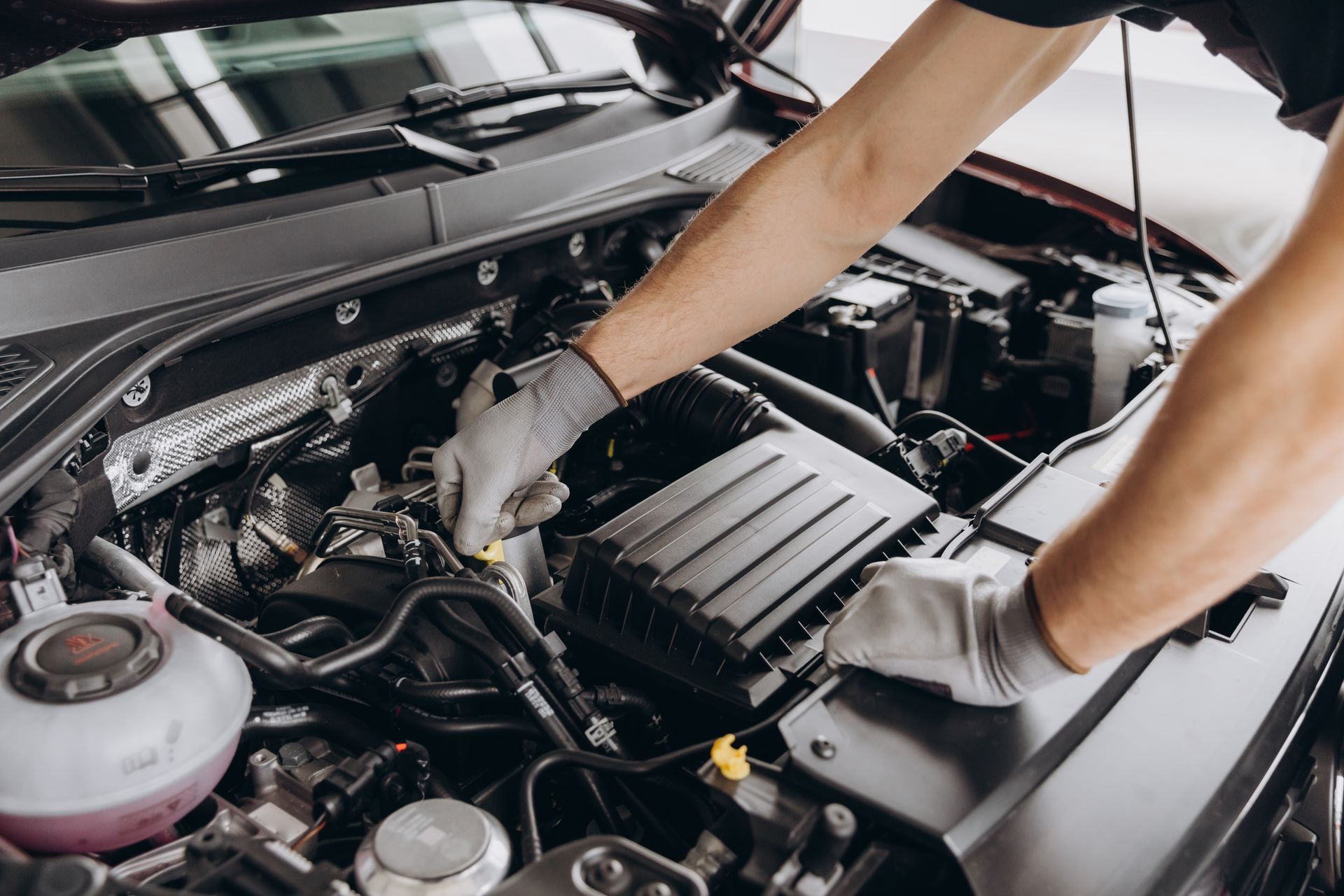 A Person is Repairing a Car Battery — Jim Wall Automotive in Moss Vale, NSW