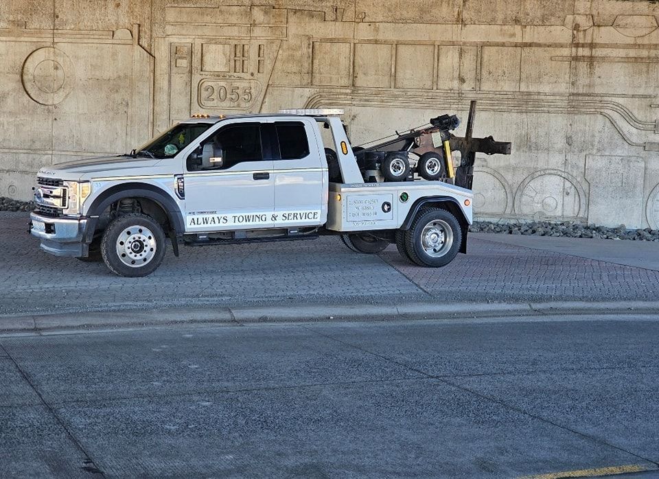 A white tow truck is parked on the side of the road.