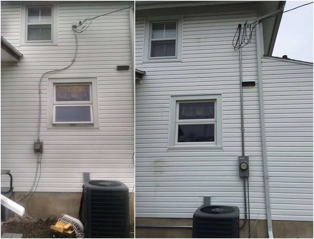 Two-story white house exterior with windows, siding, utility pipes, and air conditioning units.