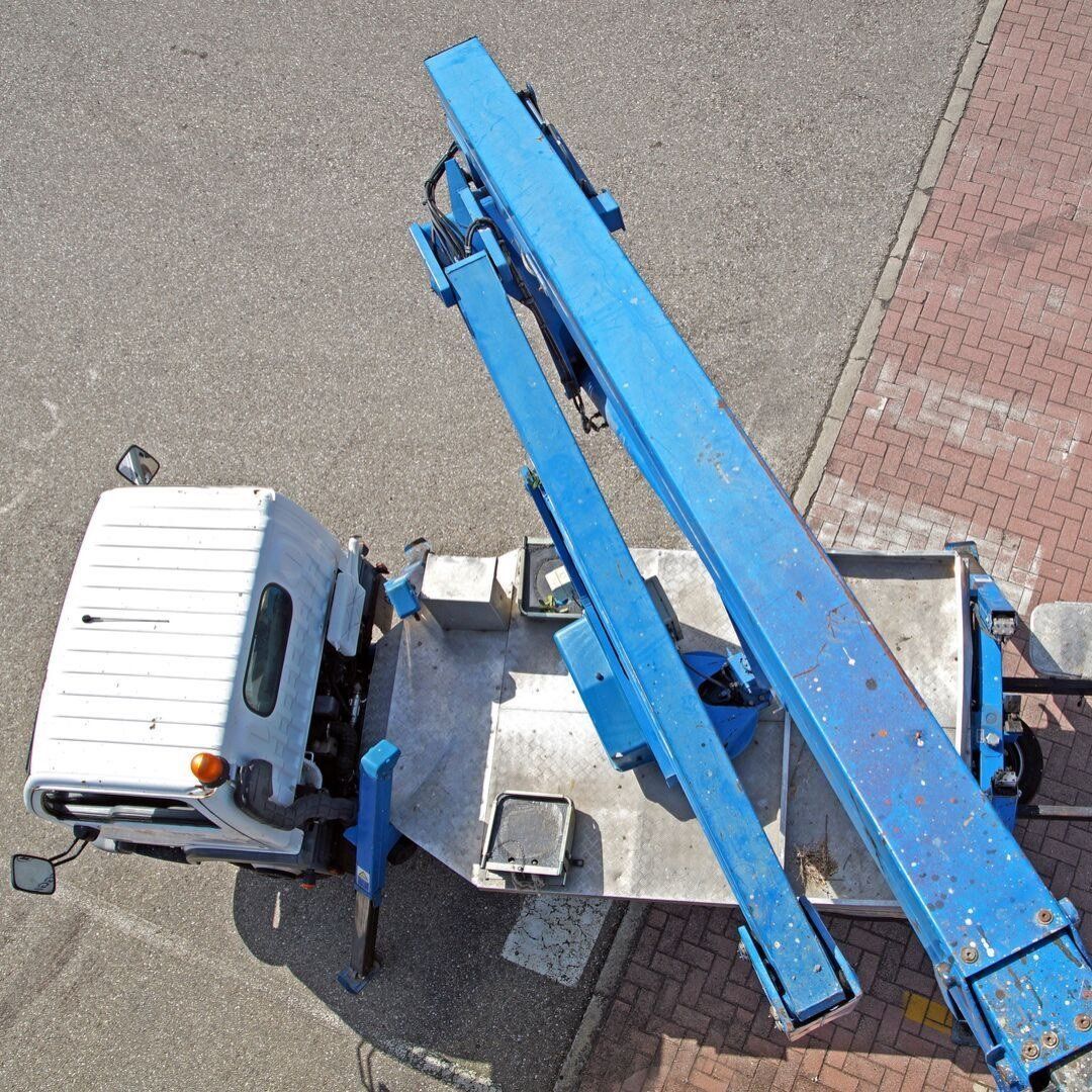 Blue bucket truck viewed from above on pavement, with extended boom arm and white cab.