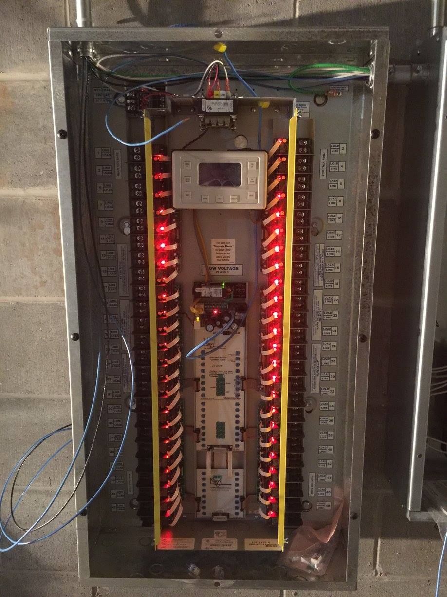 Electrical control panel with illuminated red indicator lights and wiring inside a metal cabinet