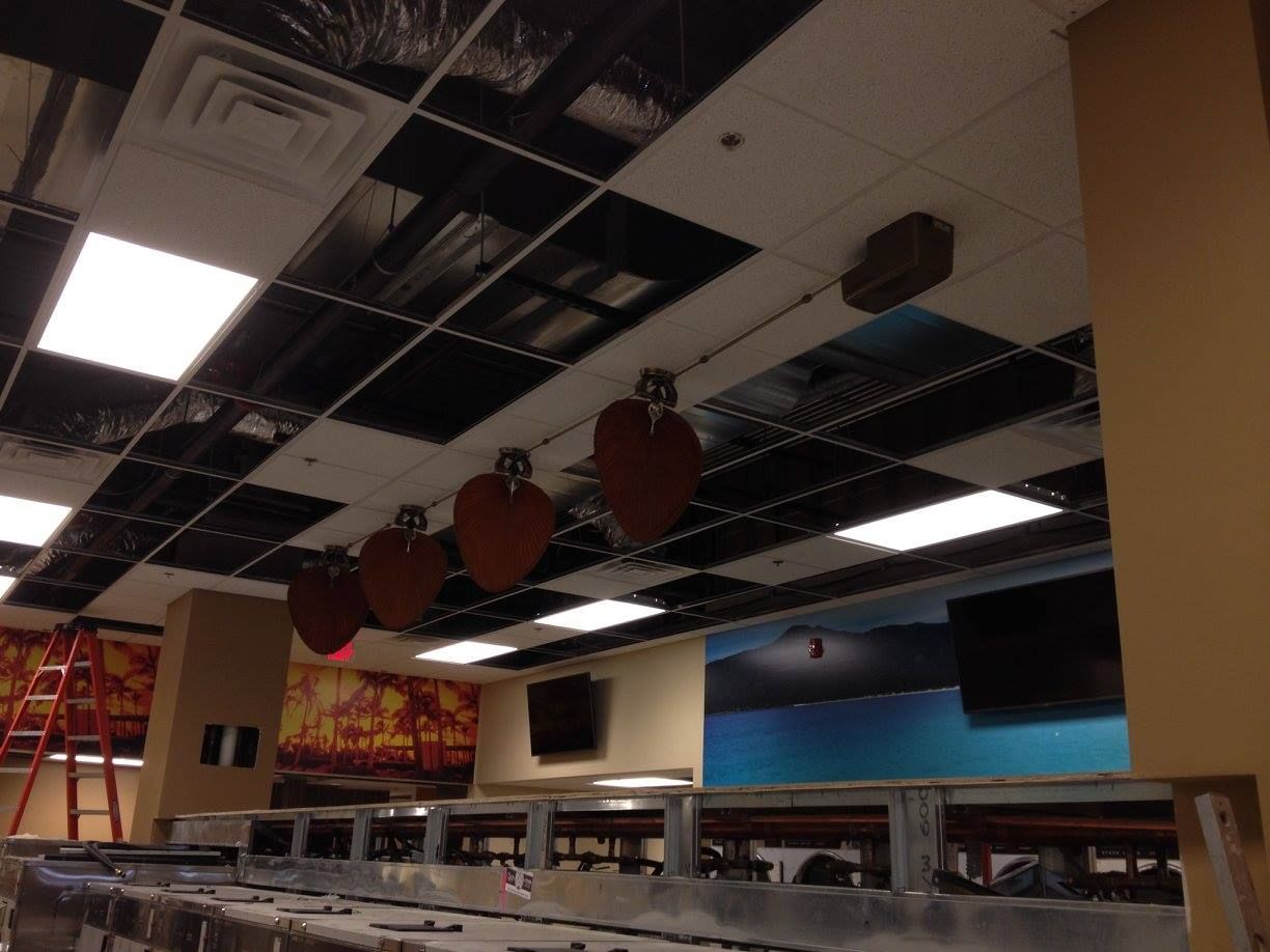 Damaged office ceiling with missing tiles, exposed wiring, and a few hanging acoustic panels