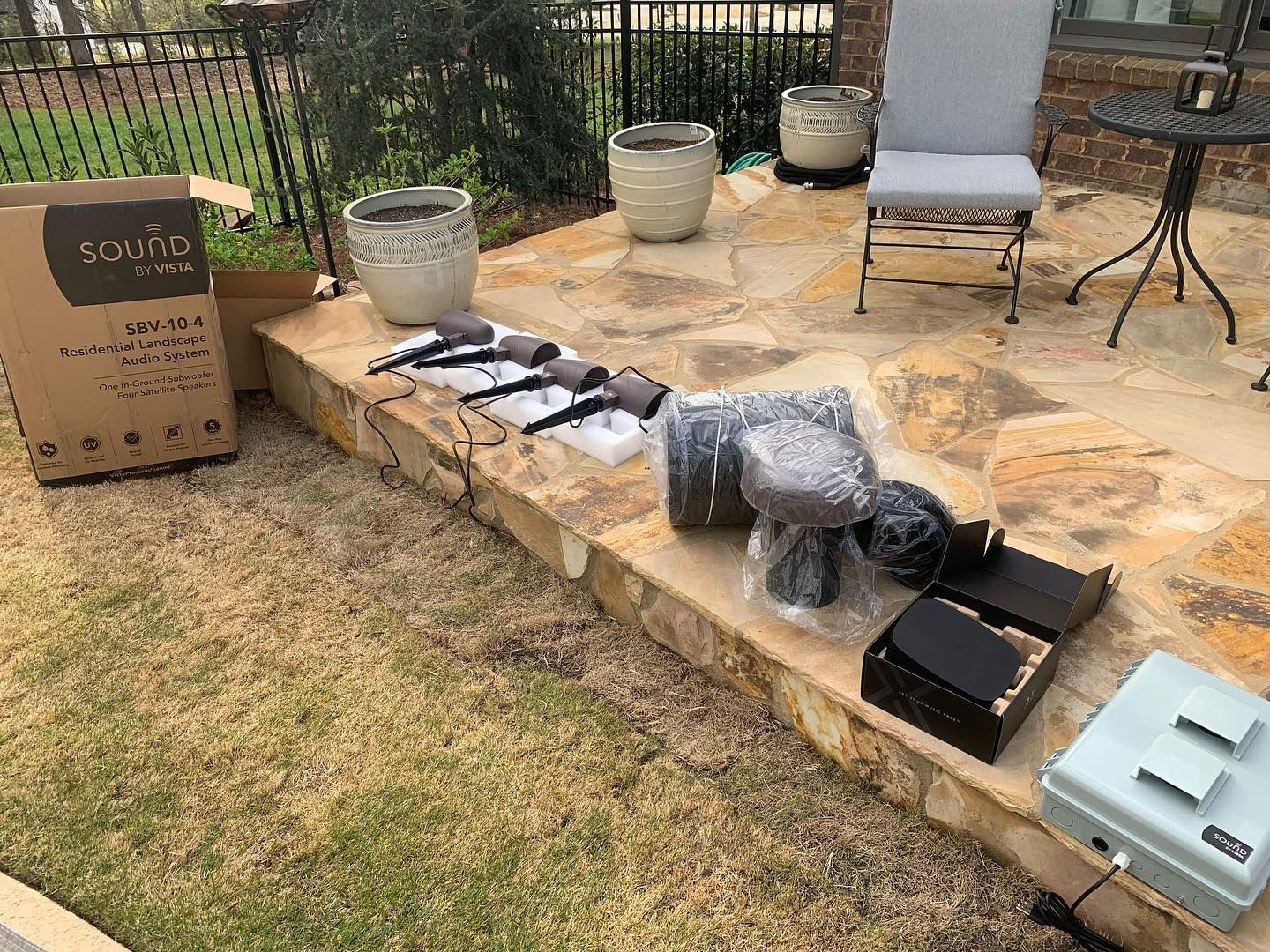 Patio with audio equipment on a stone step beside a lawn and chair