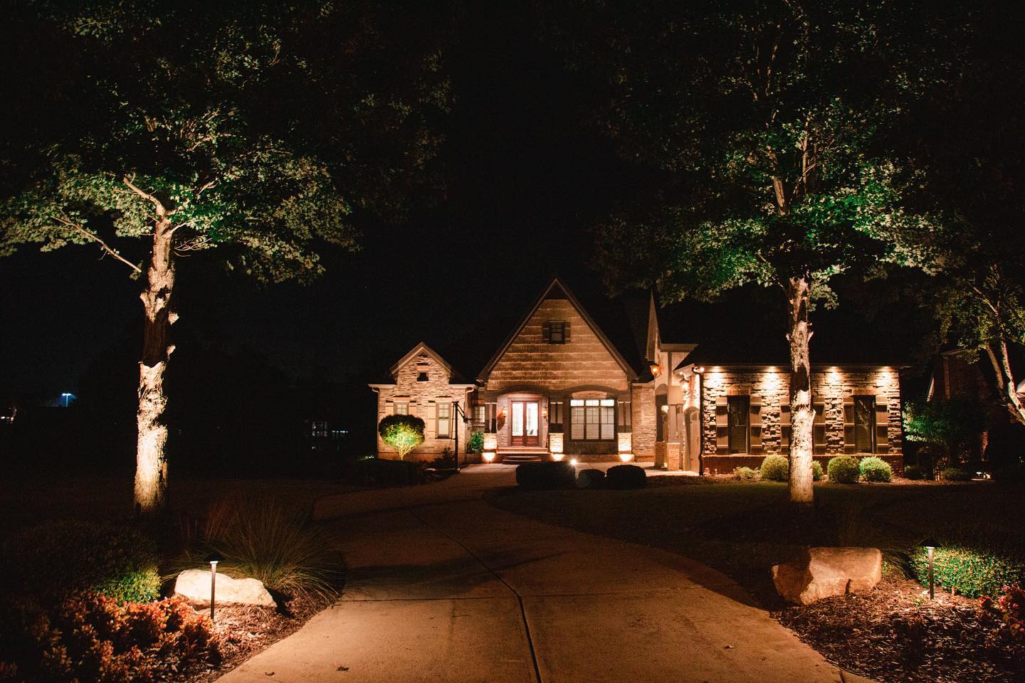 Lighted driveway leading to two-story home