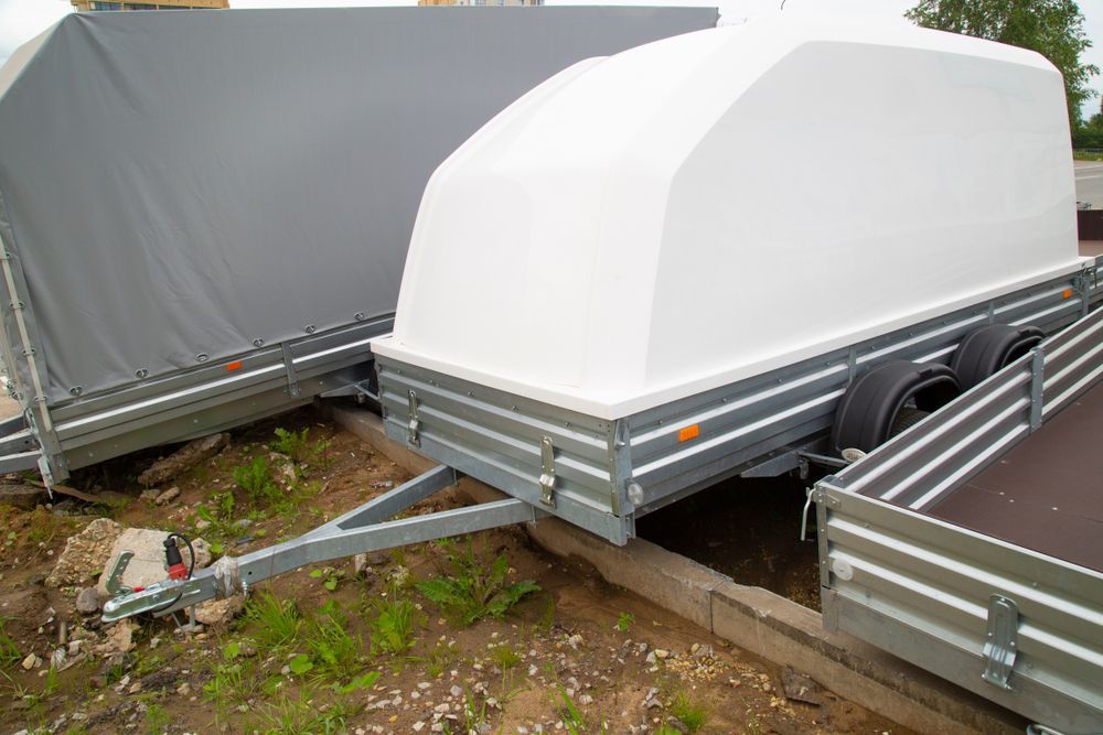 White Enclosed Trailer With a Gray Trailer Nearby — Towform Trailers in Brocklehurst, NSW