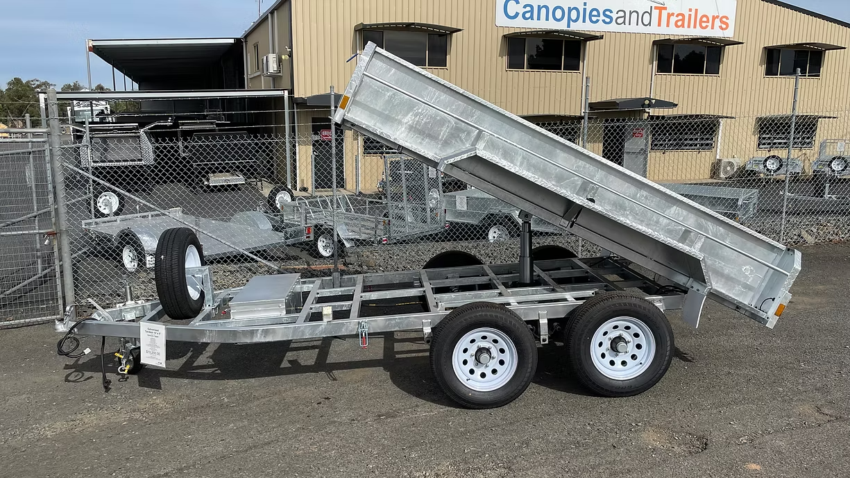 A Silver Utility Trailer With Its Bed Raised, Parked Outside A Building — Towform Trailers in Cobar, NSW