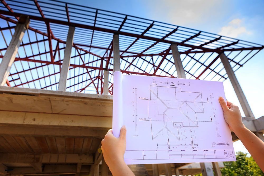 A Person is Holding a Blueprint of a Building Under Construction — A. Webber Building in Nowra, NSW