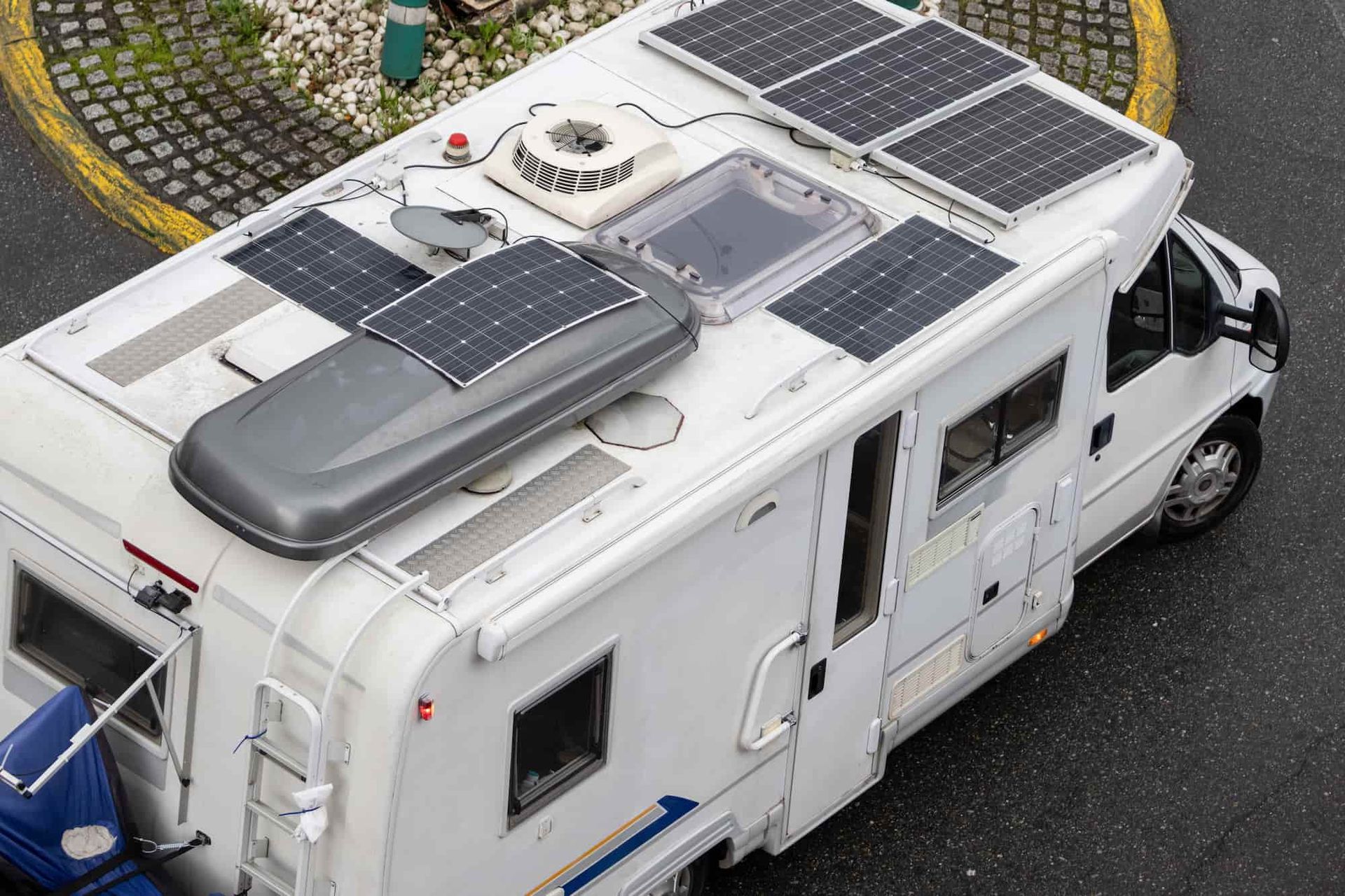 A White Rv With Solar Panels on the Roof is Parked in a Parking Lot — Bowen Mechanical & Haulage in Bowen, QLD