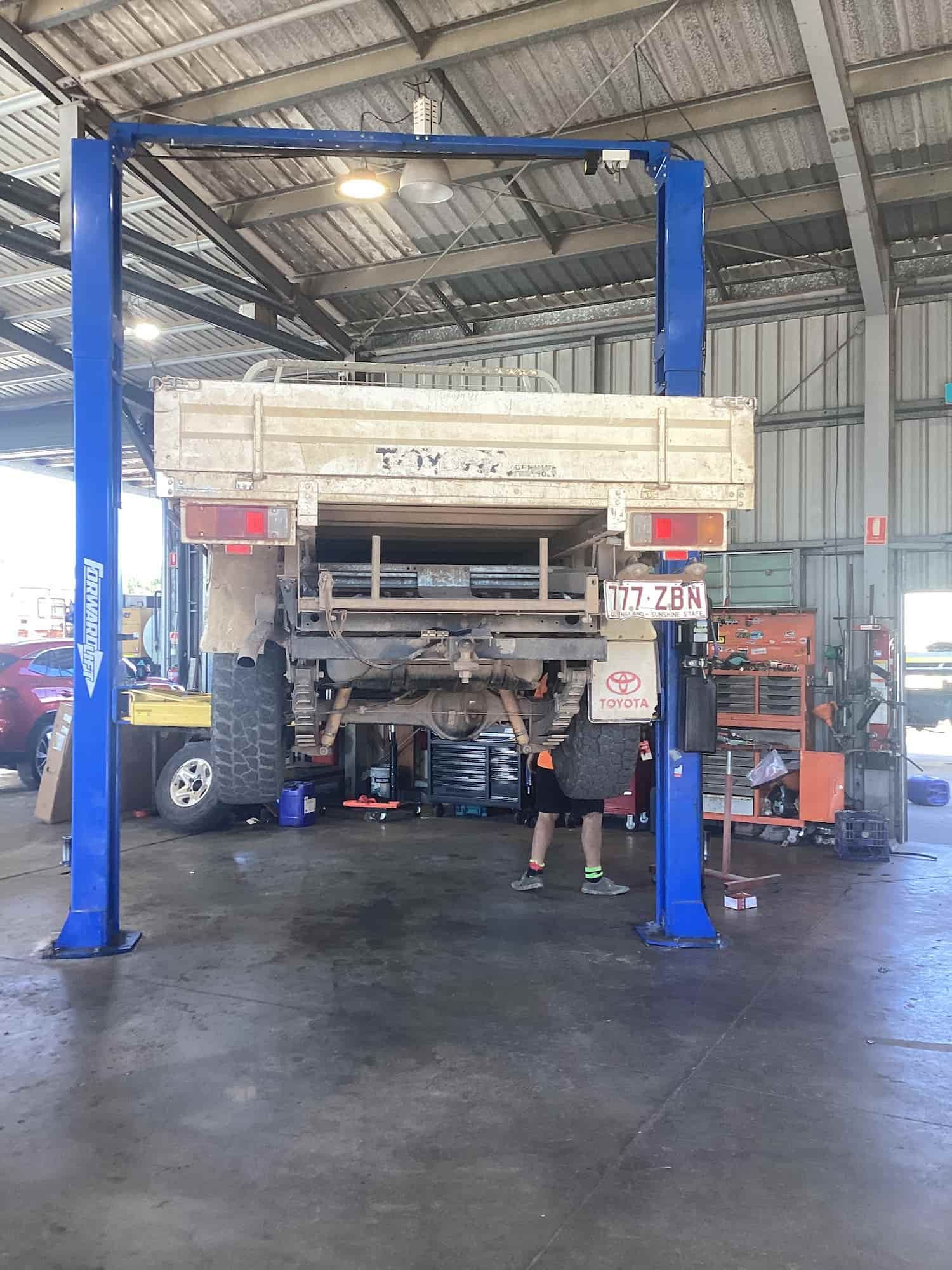 A Truck is Sitting on a Lift in a Garage — Bowen Mechanical & Haulage in Bowen, QLD