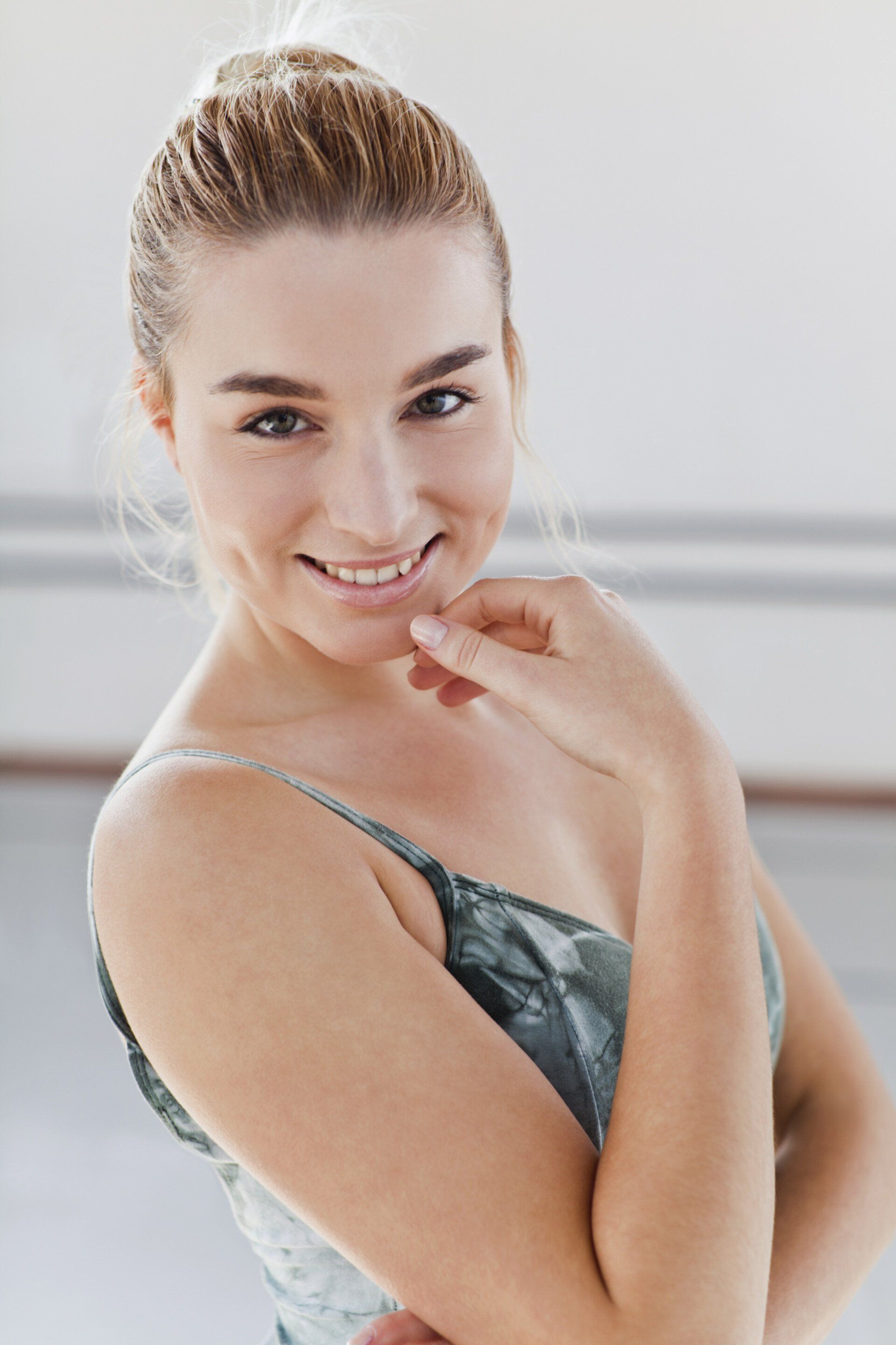 A woman looking down holding on to her chin