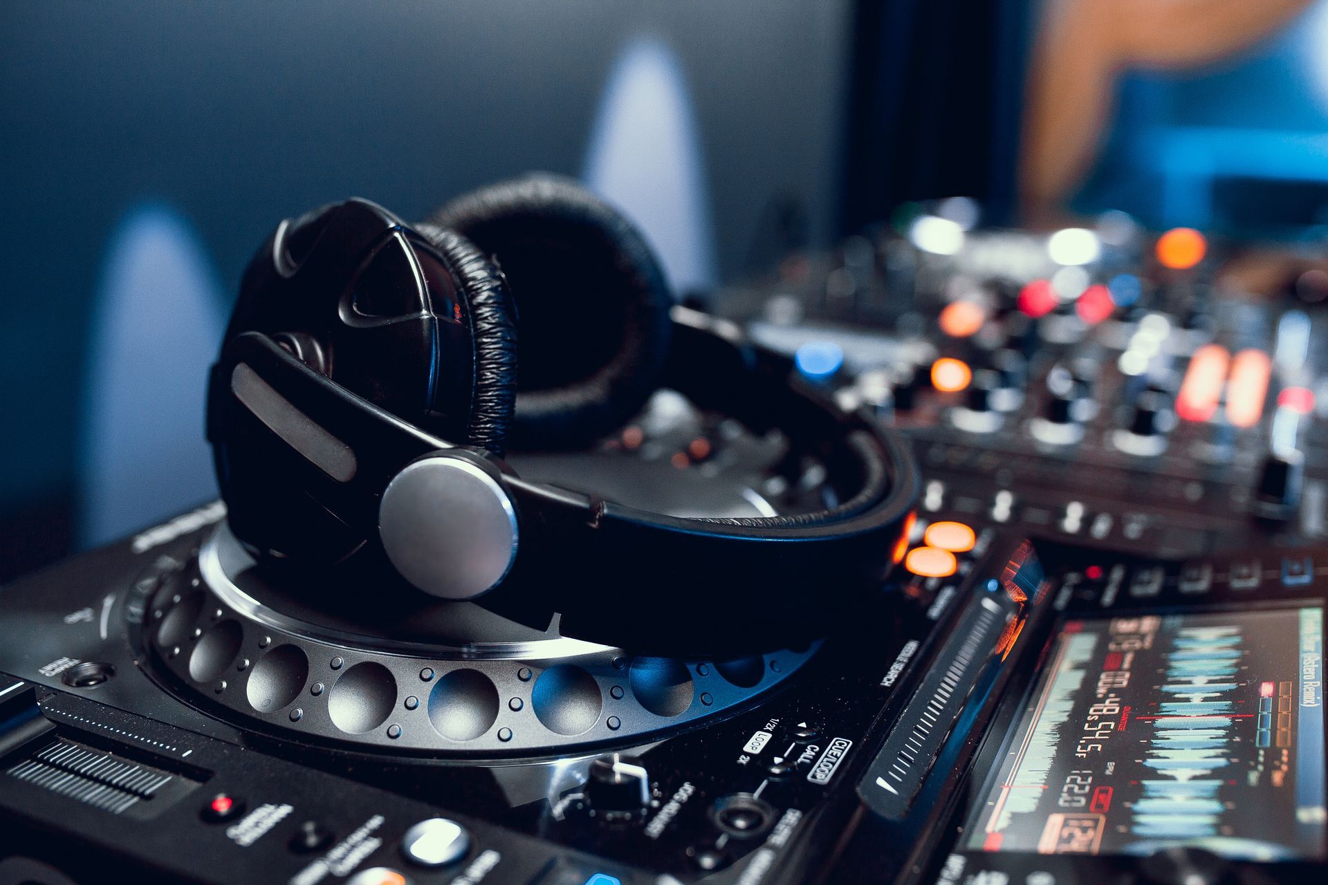 A pair of headphones sitting on top of a dj controller.