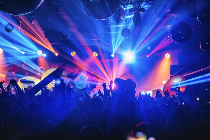 A crowd of people are standing in front of a stage at a concert.