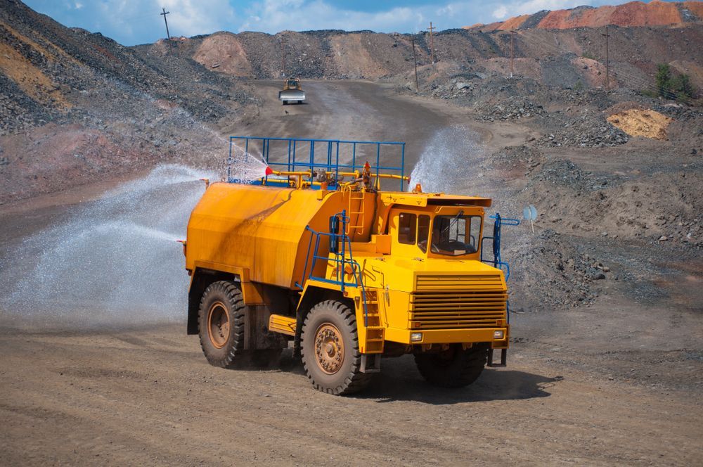 Yellow Water Truck Spraying Water in a Quarry — PBC Compliancing in Whitsundays, QLD