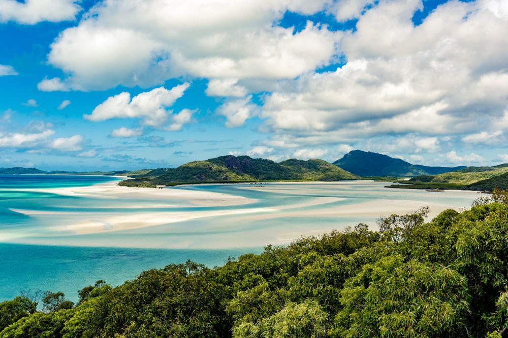 A Large Body of Water Surrounded by Trees and Mountains — PBC Compliancing in Whitsundays, QLD