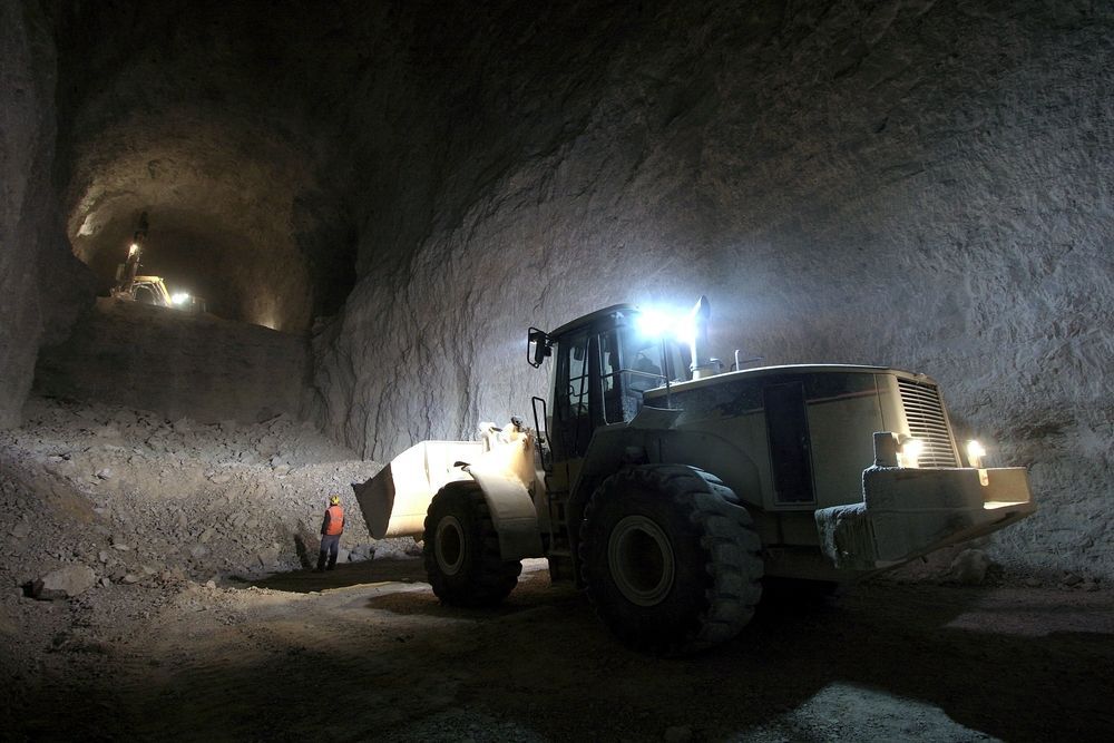 A Bulldozer Is Driving Down a Dirt Road in A Cave — PBC Compliancing in Mackay, QLD