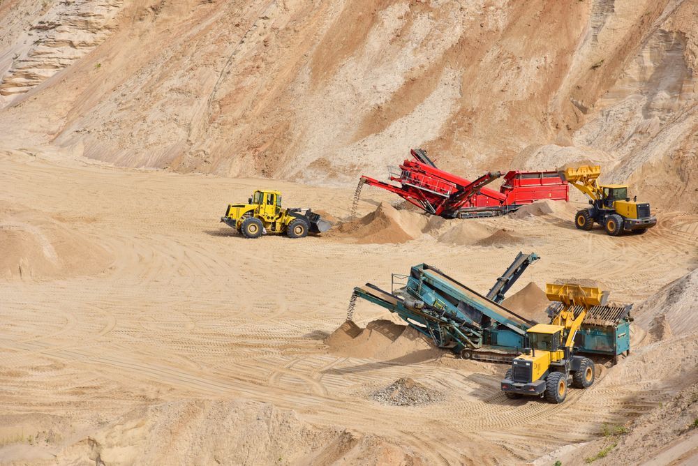 A Group of Trucks Are Working in A Sand Quarry — PBC Compliancing in Bowen Basin, QLD