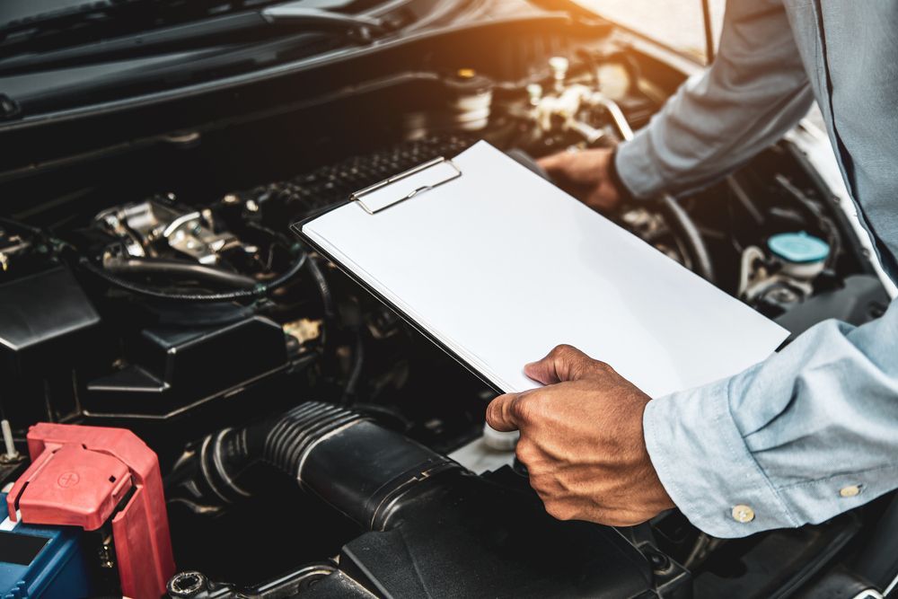 Man Checking The Car While Holding The Clipboard — PBC Compliancing in Rockhampton, QLD
