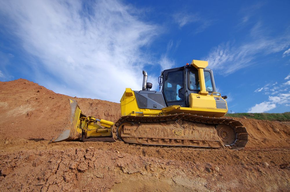 Yellow Bulldozer On A Dirt Road— PBC Compliancing in Nebo, QLD