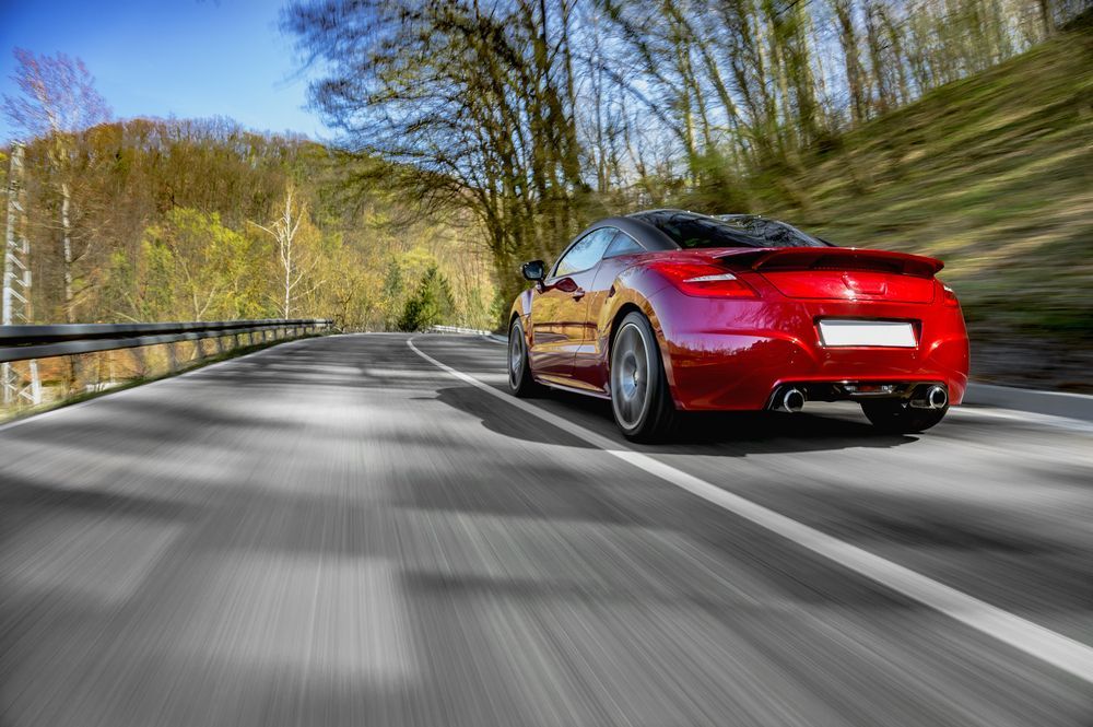 Red Sports Car Driving Fast On The Road — PBC Compliancing in Townsville, QLD