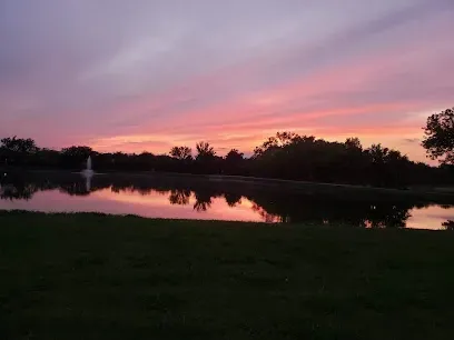 AT Electric LLC - The image captures a breathtaking view of the sky painted in shades of pink and purple, reflecting beautifully on the calm water.