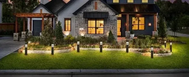 Local Electricians - This image showcases a modern home with a well-lit front yard, featuring stylish LED bollard lights illuminating the garden and walkway.