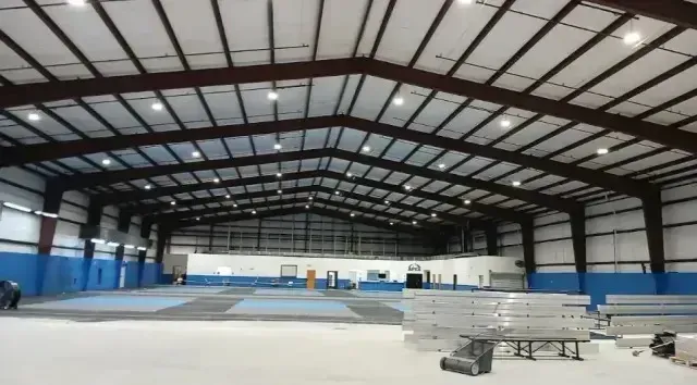 This spacious commercial building is equipped with high-quality lighting installations carried out by experienced local electricians. The bright overhead lights ensure optimal visibility across the entire indoor space, making it suitable for various activities and operations