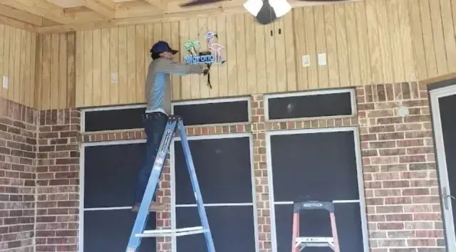 Local Electricians – Local electricians are seen installing an outdoor neon sign on a covered patio, demonstrating their expertise in handling both indoor and outdoor electrical projects.