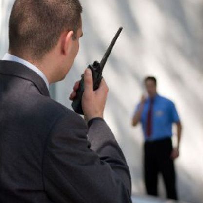 A man in a suit is talking on a walkie talkie