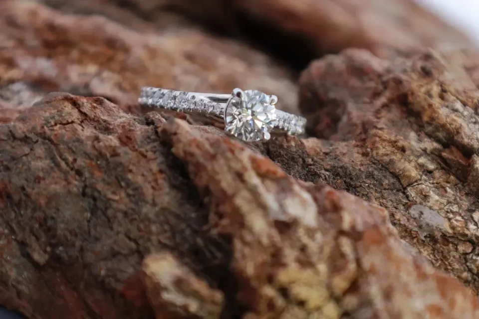 Diamond engagement ring on textured brown rock surface