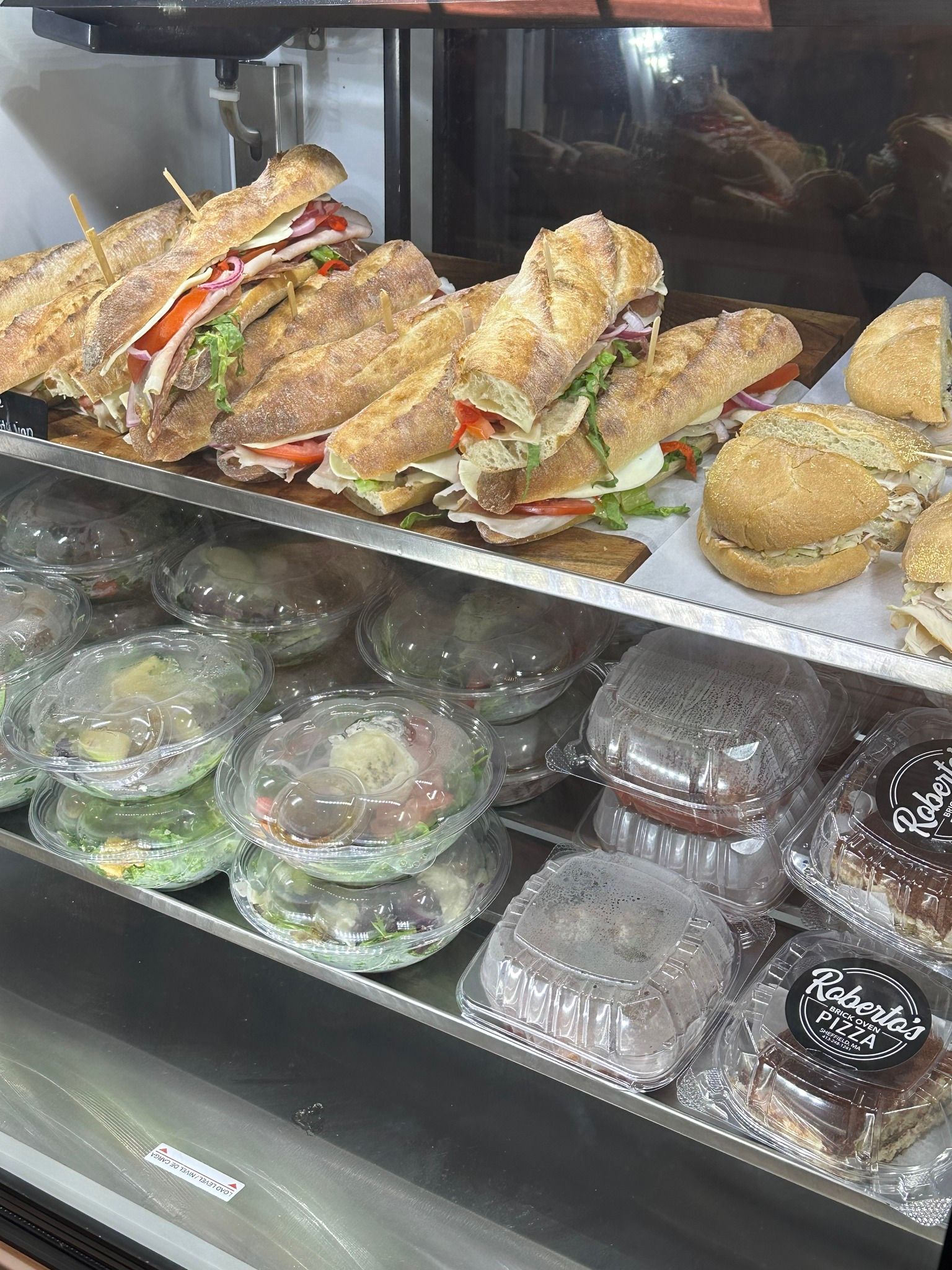 Display case with sandwiches and salads.