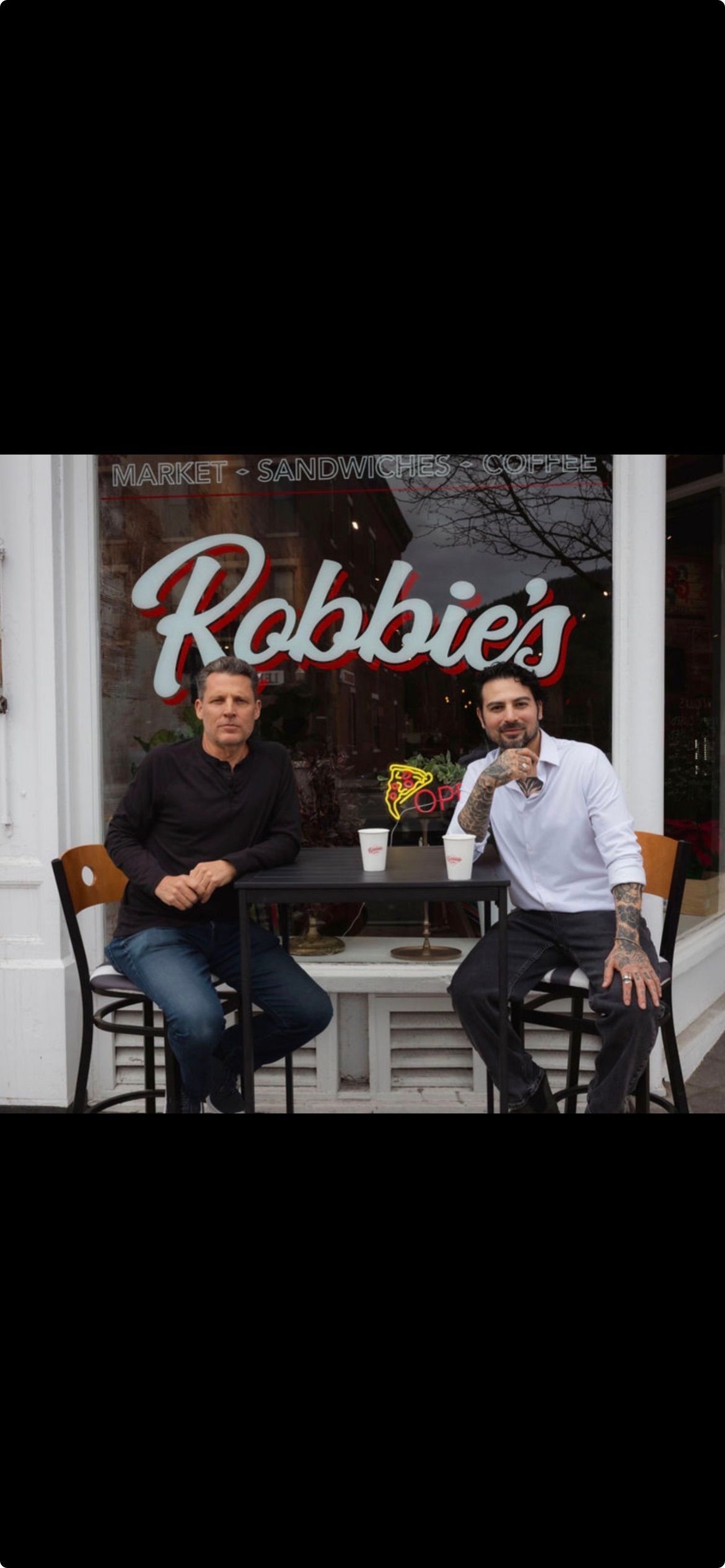 Two men toasting outside 