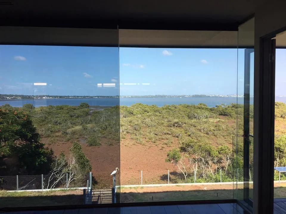 A Large Window with A View of A Field and A Body of Water — Solarmaster in Gold Coast, QLD 